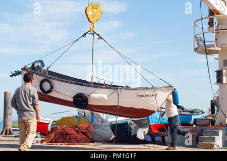 Levage hommes Bateau de pêche pour mettre dans l'eau à l'aide de bateau grue Banque D'Images