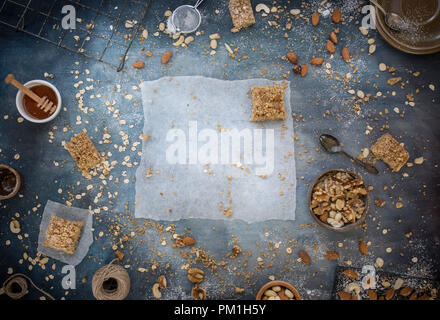 Des tranches au caramel du papier sulfurisé, avec un fond bleu texturé y compris les noix, graines et céréales une flatlay frais généraux de droit, partie d'une série Banque D'Images