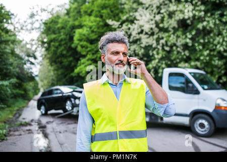 Young man making a phone call après un accident de voiture. Copier l'espace. Banque D'Images