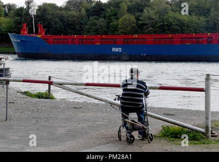 04 septembre 2018, le Schleswig-Holstein, Landwehr : 04 septembre 2018, l'Allemagne, la Landwehr : Un homme regarde les navires de passage sur le Canal de Kiel à la station de ferry de Landwehr. (Sur 'DPA Expansion du canal de Kiel se prolonge dans les années 30') Photo : Carsten Rehder/dpa Banque D'Images