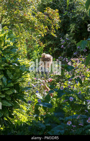 Une jeune femme jardinier à Great Dixter plantes postes dans la longue frontière afin qu'un autre jardinier peut décider l'emplacement, Rye, East Sussex, UK Banque D'Images