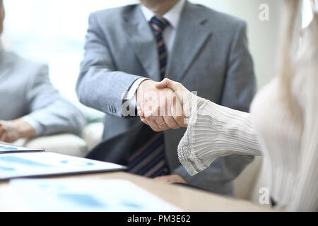 Close up.La poignée de main d'un homme et femme d'affaires sur un bureau Banque D'Images