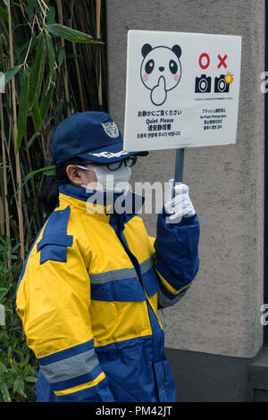 Équipier avec panneau d'avertissement près de la cage à la panda zoo de Ueno à Tokyo, Japon, Asie Banque D'Images