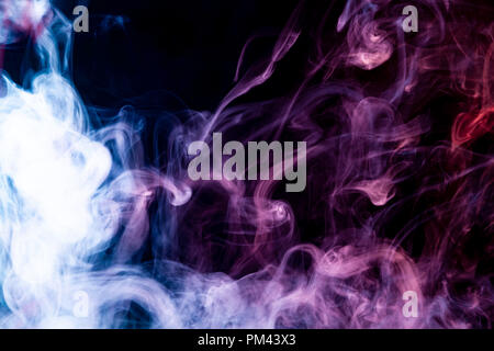 Nuage de rose, rouge et bleu de la fumée sur un arrière-plan noir isolé. Contexte de la fumée de vape Banque D'Images