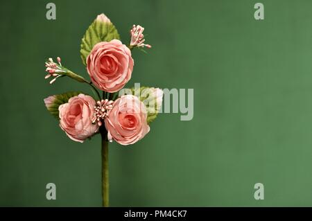 Souche artificielle avec trois roses sur fond vert. Copier l'espace, vue avant Banque D'Images