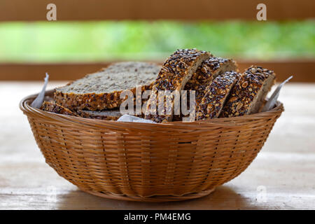 Panier avec des tranches de pain avec des graines sur la table en été Banque D'Images