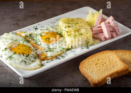 Oeufs au plat avec du fromage fondu et du cas roumain appelé quelques parizer avec toast Banque D'Images