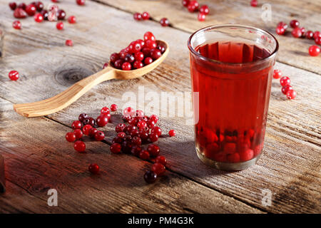 Vitamine boire du jus de canneberge rafraîchissante dans un verre sur un fond de bois Banque D'Images