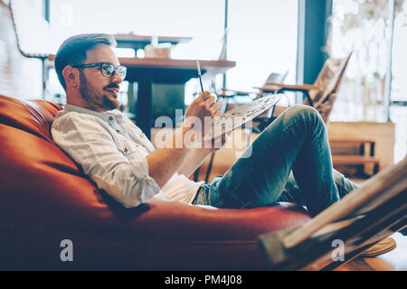 Portrait d'artistes masculins travaillant sur la peinture en Studio Banque D'Images