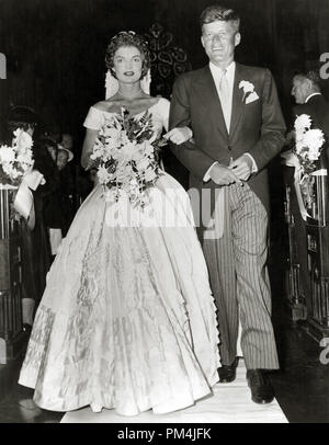 Le sénateur John F. Kennedy et de l'épouse Jacqueline Lee Bouvier marcher dans l'allée de l'église peu après leur cérémonie de mariage dans la matinée du 12 septembre 1953, à l'Église Catholique Romaine Ste Marie à Newport, Rhode Island. Les plus de huit cents invités inclus de nombreux individus. La mariée porte une robe de soie tissu ivoire, avec un portrait de l'encolure, corsage ajusté, et un bouffant jupe ornée de bandes de plus de cinquante mètres de volants. Jacqueline portait un collier de perles et un bracelet de diamant qui a été un cadeau du marié. Le bouquet de rose et de blanc a été pulvérisée et orchidées Banque D'Images