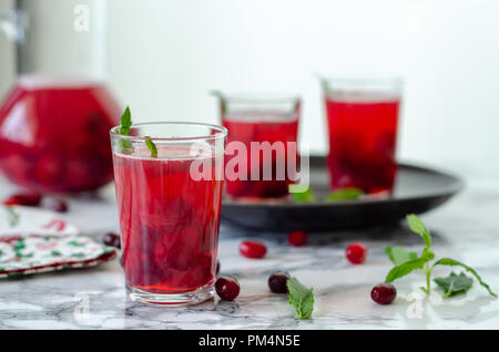 Femme est le remplissage en verre de jus de canneberge.C'est sain de boire. Banque D'Images