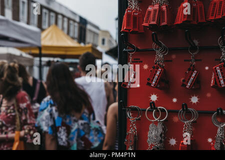 Londres, Royaume-Uni - 21 juillet 2018 : les touristes en passant devant un stand avec porte-clés souvenir en vente sur le marché de Portobello, Londres, l'un des plus populaires touris Banque D'Images