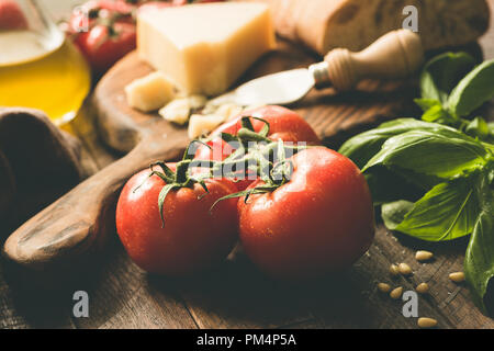 Tomates sur vigne, parmesan, huile d'olive, basilic et pain ciabatta. La cuisine italienne ingrédients alimentaires. Vue rapprochée, tonique libre Banque D'Images