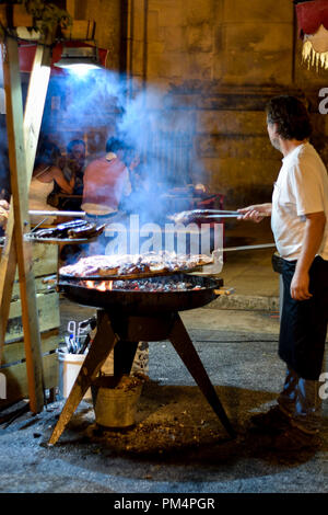 Portugais cuisine traditionnelle de tapas et grillades, homme grill chorizo et viande dans les rues à l'événement local dans la ville de Braga au Portugal. Portugal gastronomie Banque D'Images