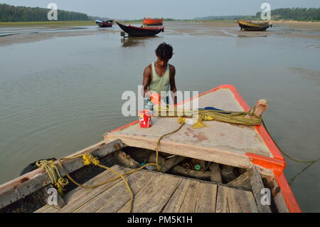 Un pêcheur peint son bateau après pour aller à la pêche Banque D'Images