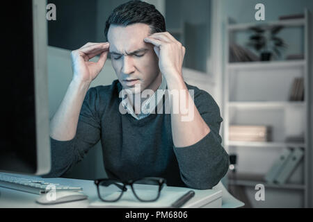 Homme intelligent fatigué ses tempes massage relaxant Banque D'Images