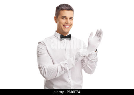 Jeune homme en smoking mettre des gants isolé sur fond blanc Banque D'Images