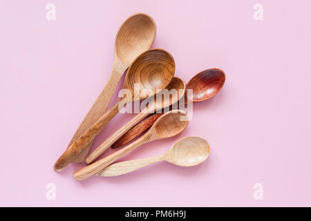 Cuillères en bois sur fond rose. Des ustensiles de cuisine à la mode, respectueux de l'environnement Eco cuillères en bambou Banque D'Images