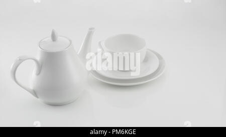 Théière avec tasse en céramique blanche sur fond clair Banque D'Images