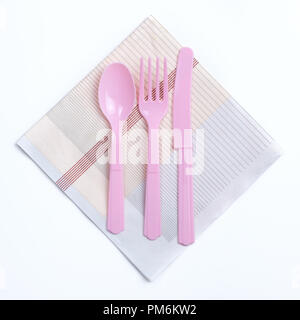 Fourchette en plastique de couleur rose, cuillère et couteau sur nappes Banque D'Images