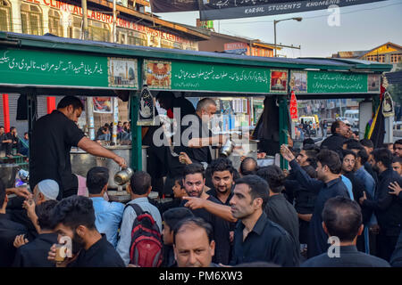 Verres de thé est donné à la deuil chiite au cours de 6e jour de l'Ashoura procession à Srinagar le lundi. Musulman chiite commémore Muharram, le premier mois du calendrier lunaire, comme mois de deuil en souvenir du martyre du prophète Muhammad SAWS Islamique petit-fils de l'Imam Hussain (PSL) qui a été martyrisé sur 10e jour de Mouharram en bataille de Karbala en 680 A.D certains il y a 1400 ans. Banque D'Images