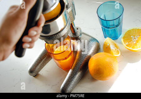 Close up of young woman mains faisant de limonade fraîche, jus réduit d'agrumes, un presse-agrumes Banque D'Images