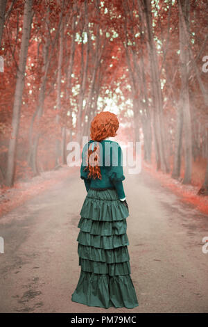 Victorian woman standing on country road avec les arbres d'automne Banque D'Images