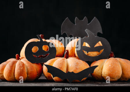 Des gâteaux d'halloween en forme de citrouille sur fond sombre. Hallooween sweets Banque D'Images