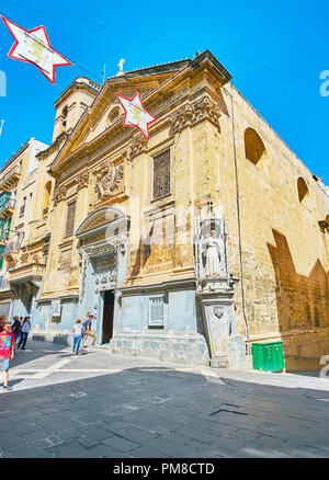 La Valette, MALTE - 17 juin 2018 : La façade de l'église de Saint François d'assise avec des pierres sculptées de guirlandes et de la sculpture de Saint François sur buildi Banque D'Images