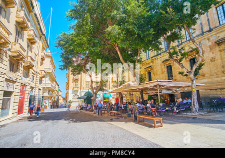 La Valette, MALTE - 17 juin 2018 : l'agréable café en plein air est masqué dans l'ombre des arbres à St John Street, le 17 juin à La Valette. Banque D'Images