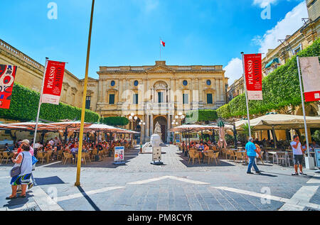 La Valette, MALTE - 17 juin 2018 : la pittoresque cafés en plein air sur la place de la République avec une vue sur la Bibliothèque Nationale de Malte sur l'arrière-plan, le 17 juin à Val Banque D'Images