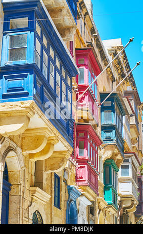 L'accrocheur, d'un balcon maltais en bois décorées avec des couleurs vives et des reliefs, St Paul Street, Valletta, Malte. Banque D'Images