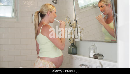 Femme enceinte se brosser les dents Banque D'Images