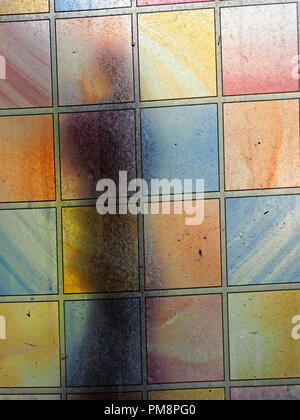 Ombre sur vitrail crasseux avec panneaux contrastés pastel rectangulaire, Ariège Pyrénées, France Banque D'Images