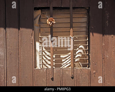 Les ombres déformées des barres parallèles de la fenêtre en bois brun des capacités en Ariège Pyrénées, France Banque D'Images