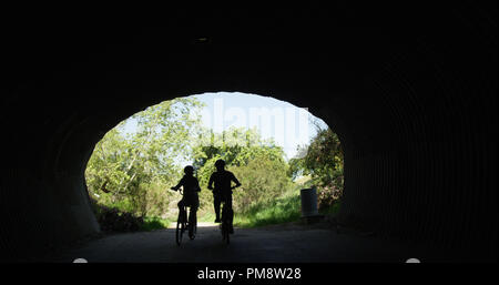 Personnes âgées en bonne santé couple riding bikes in tunnel Banque D'Images