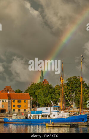 Un arc-en-ciel s'élève au-dessus d'un navire amarré à Helsingor, Danemark. Banque D'Images