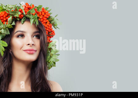 Belle jeune femme avec une peau saine, long cheveux bouclés et feuilles vertes, soins capillaires et soins concept Banque D'Images