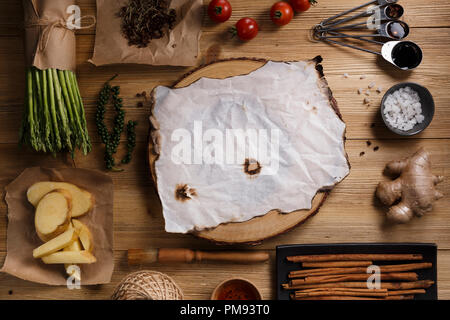 Ingrédients de cuisson des aliments thaïlandais aux asperges, le poivre, le gingembre, sel, poivre de cayenne, la sauce de poisson, pinceau, tomates, planche à découper en bois et papier sur boa Banque D'Images