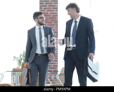 Deux hommes d'en marchant le long d'un immeuble de bureaux moderne Banque D'Images