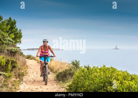 La Croatie, Pula, Le Cap Kamenjak, mountainbiker sur le littoral Banque D'Images