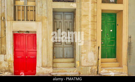 Trois vieilles portes colorées lumineuses dans Old Mint Street, le rouge est plus bas que le niveau du sol et deux autres ont certaines étapes, Vieux Mint Street, Valletta, Banque D'Images
