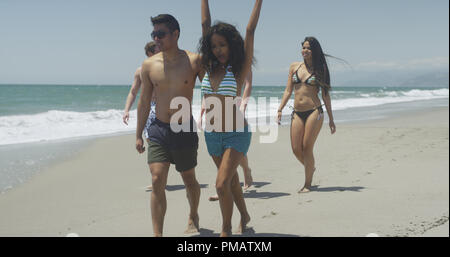 Groupe de jeunes amis interracial adultes fonctionnant sur la plage Banque D'Images