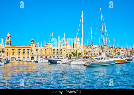 Bâtiment historique du musée maritime de Malte avec tour de l'horloge est reflétée dans des eaux bleu azur de Vittoriosa marina, plein de yachts et bateaux, Birgu, Malt Banque D'Images