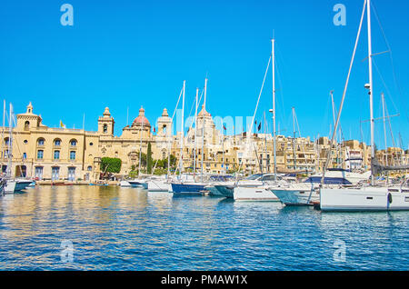 La façade du Saint Laurent (San Lawrenz) Église avec dôme gigantesque et clochers pittoresques sur la côte de Birgu avec de nombreux yachts de Vittoriosa marina o Banque D'Images