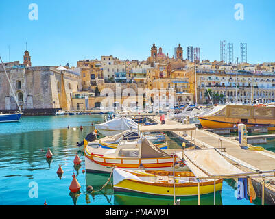 Luzzu traditionnel de Vittoriosa bateaux de plaisance avec une vue sur les toits de Senglea avec Nativité de Marie Basilique sur l'arrière-plan, Birgu, Malte. Banque D'Images