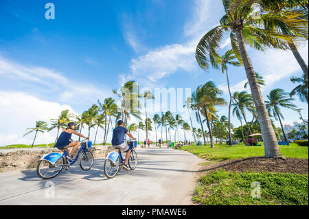 MIAMI, USA - CIRCA Juin 2017 : les touristes ride 'Vélos' actions Citi vélo le long de la promenade de Miami Beach avec fond de palmiers Banque D'Images