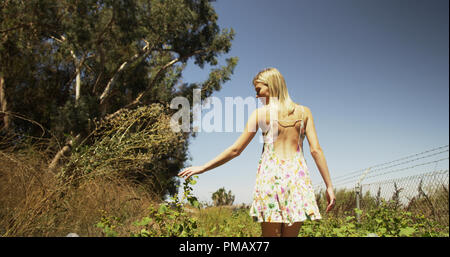 Attractive young woman walking in the sunlight Banque D'Images