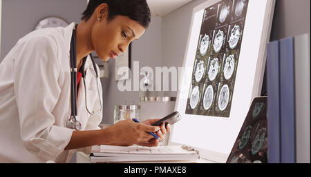 Young attractive doctor texting résultats de la scintigraphie cérébrale Banque D'Images