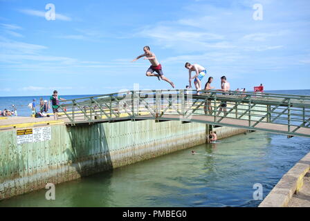 Souris, Prince Edward Island / Canada le fameux saut de pont à Singing Sands Beach, parc provincial de Basin Head, jeune garçon sautant Banque D'Images